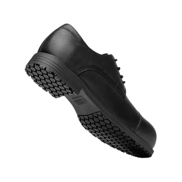 A black Shoes For Crews Senator dress shoe with a non-slip sole.