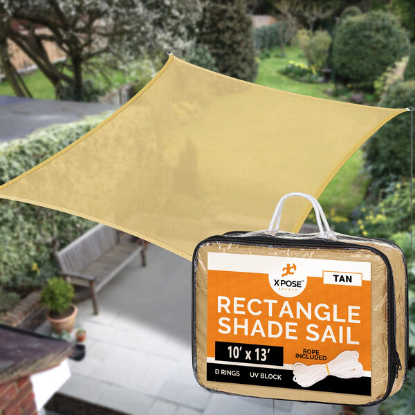 A rectangular tan Xpose Safety shade sail in a bag next to a house.