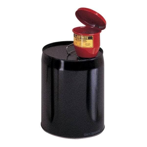 A red galvanized steel funnel with a red cap on a black drum.