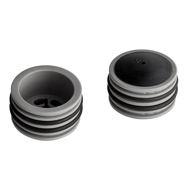 Two black and gray plastic caps with round black and white objects inside.