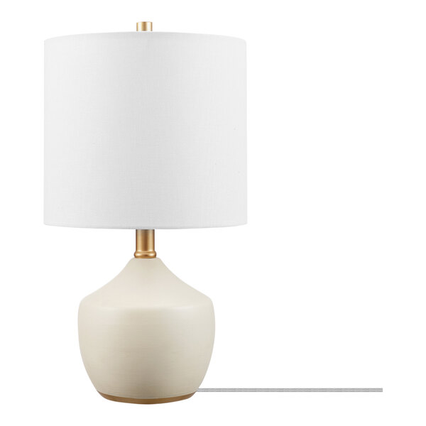 A white ceramic table lamp with brass accents and a white shade.