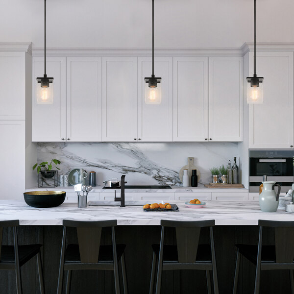 A kitchen with white cabinets and black counter tops with a Globe Modern Farmhouse Matte Black Pendant Light above the counter.