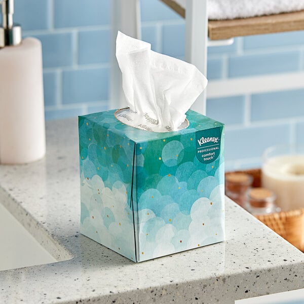 A Kleenex Professional Comfort Touch facial tissue cube on a white counter.