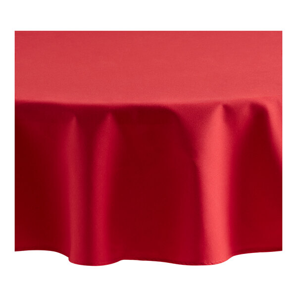 A red Oxford round tablecloth on a table.
