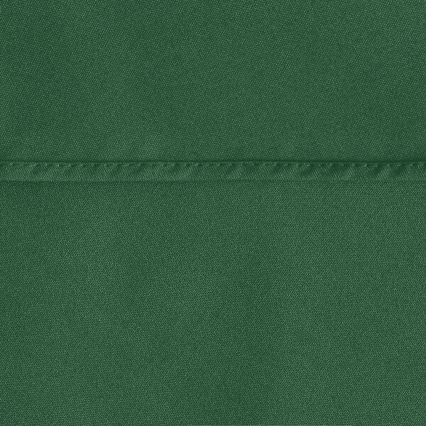 A close-up of a hunter green round table cover with a hemmed edge.