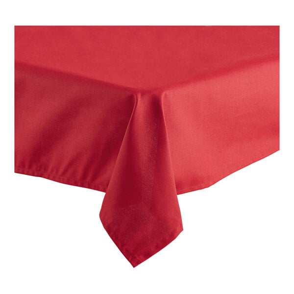 A red rectangular tablecloth with a folded edge on a table.