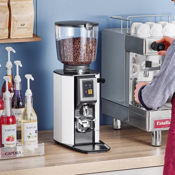 A woman using an Anfim Luna commercial espresso grinder to make coffee.