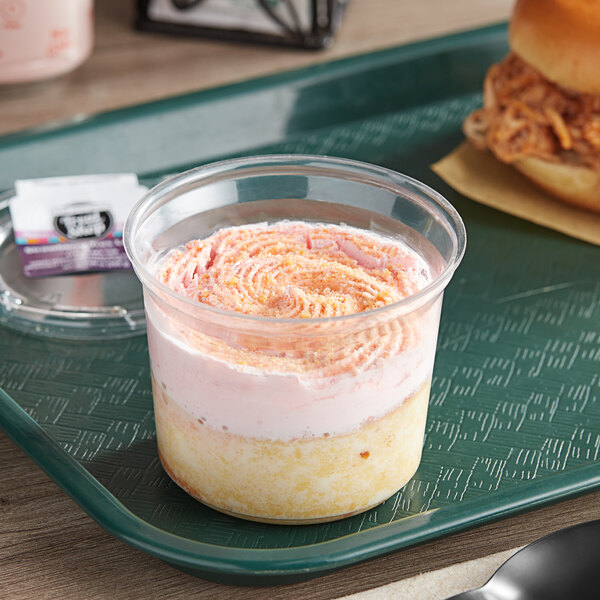 A plastic tray holding a strawberry tres leches cake cup.