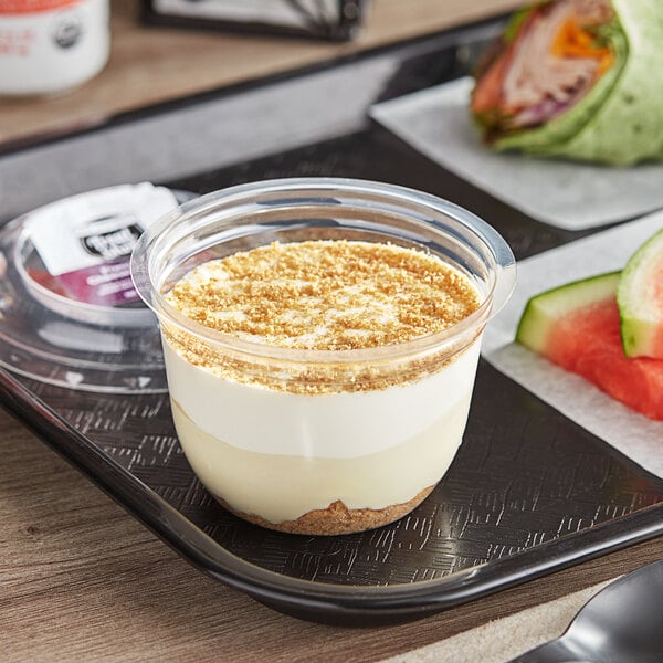 A white Our Specialty Treat Shop French-Style Cheesecake Mousse Parfait container on a tray.