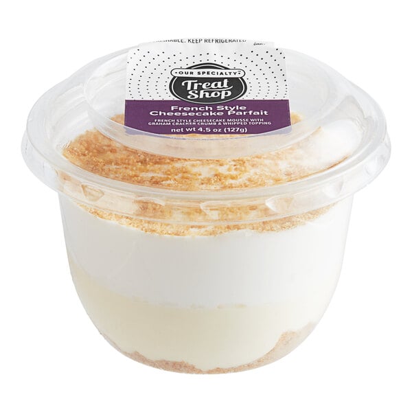A plastic Our Specialty Treat Shop French-Style Cheesecake Mousse Parfait cup with a dessert inside.