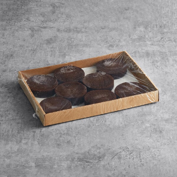 A case of Rich's Allen un-iced round chocolate cakes on a table in a bakery display.