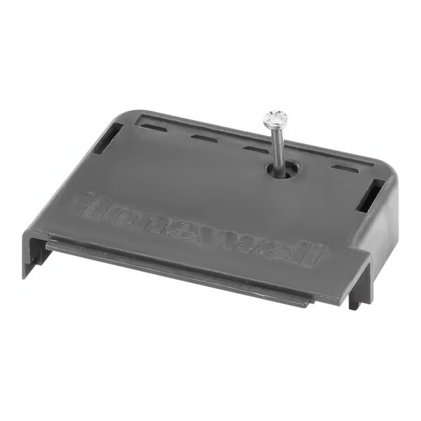 A black rectangular plastic cover with a screw on top.