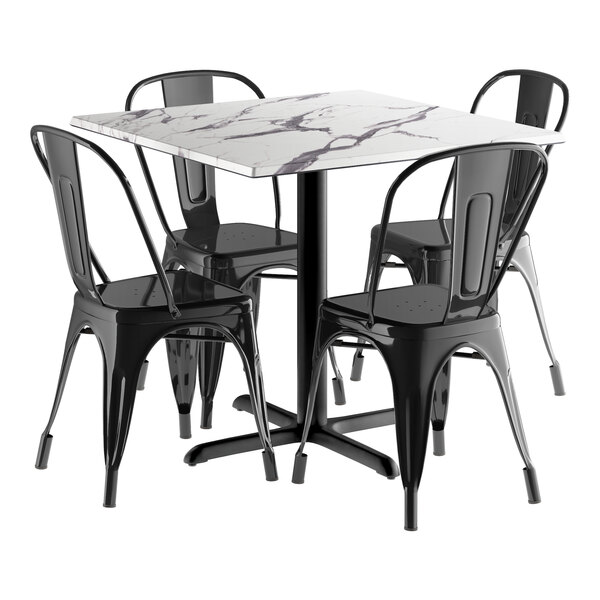 A Lancaster Table & Seating black metal table with a white surface and four black chairs.
