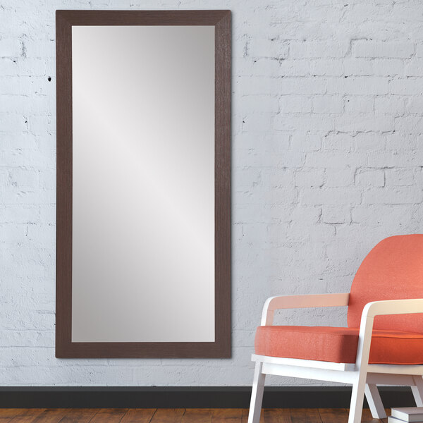 A BrandtWorks espresso finish mirror sitting against a wall.