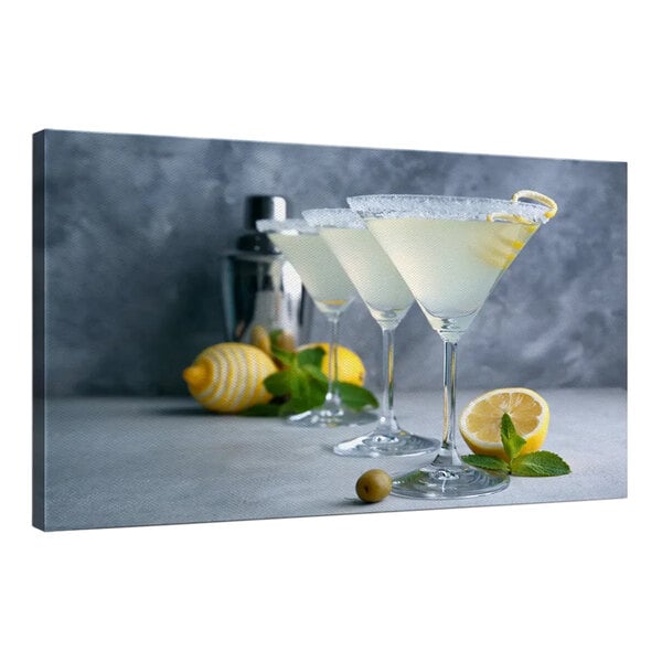 A group of martini glasses with lemon slices on the table.