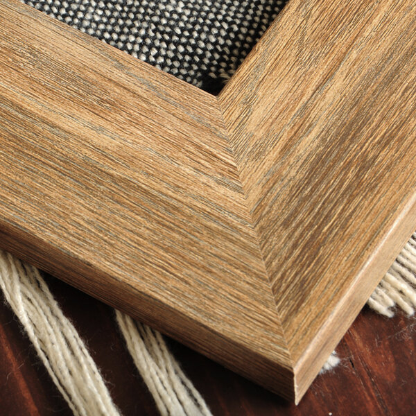 A close up of the wood frame of a BrandtWorks Blonde Barn Wall Finish Mirror.