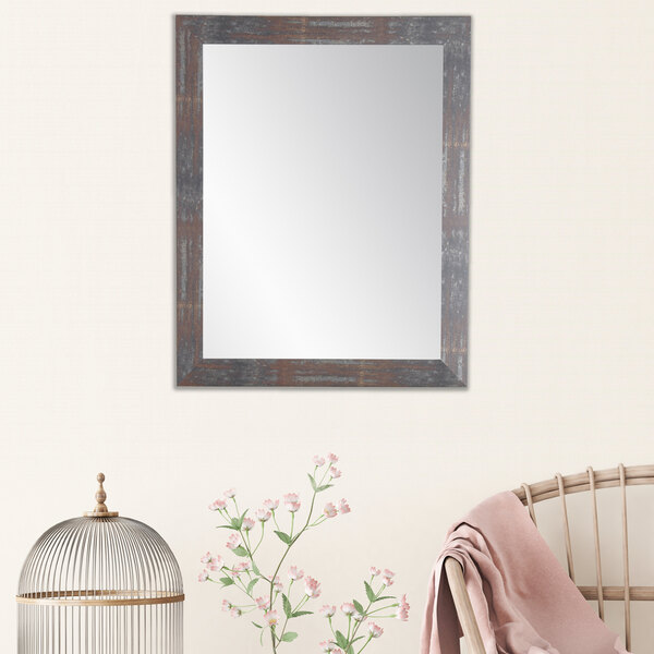 A BrandtWorks Lauralee mirror with a wooden frame on a white wall.