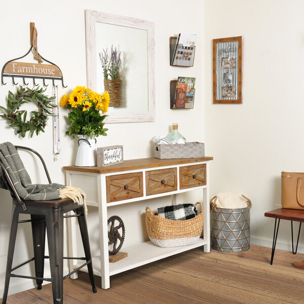 A BrandtWorks cream farmhouse grain finish mirror above a white table and chair.