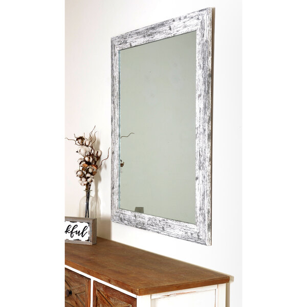 A BrandtWorks American Barn white wooden mirror on a wall.