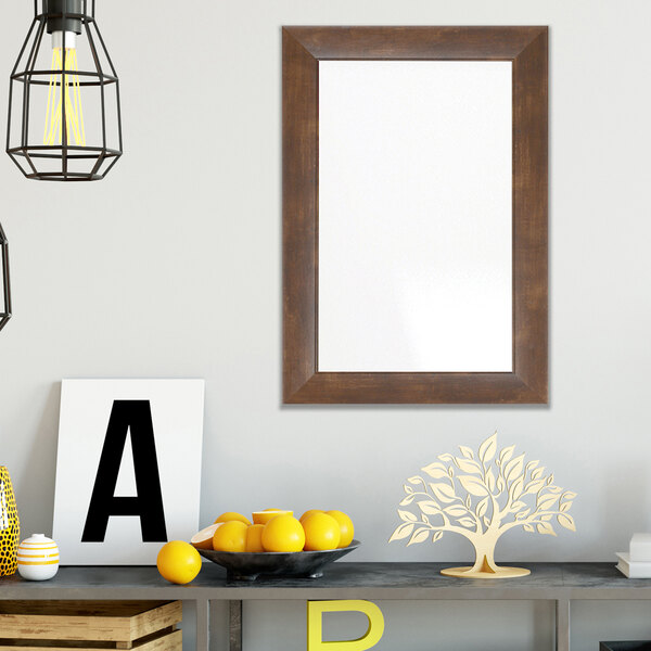 A BrandtWorks mocha walnut brown finish mirror with a tree in the reflection.