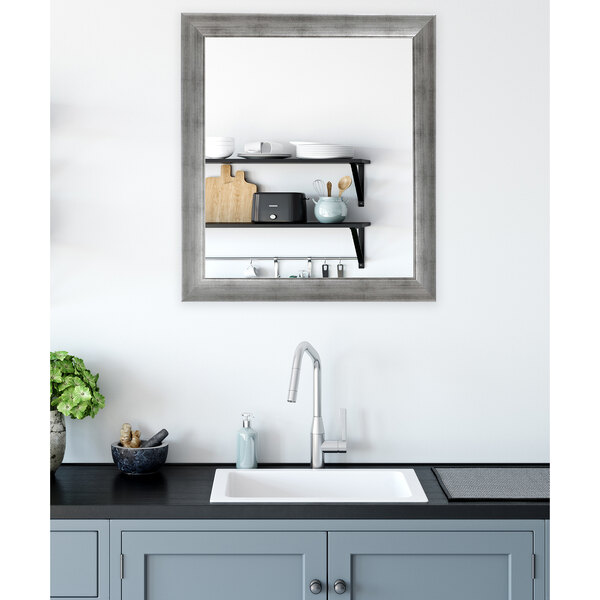 A BrandtWorks swirled silver wall mirror above a counter in a kitchen.