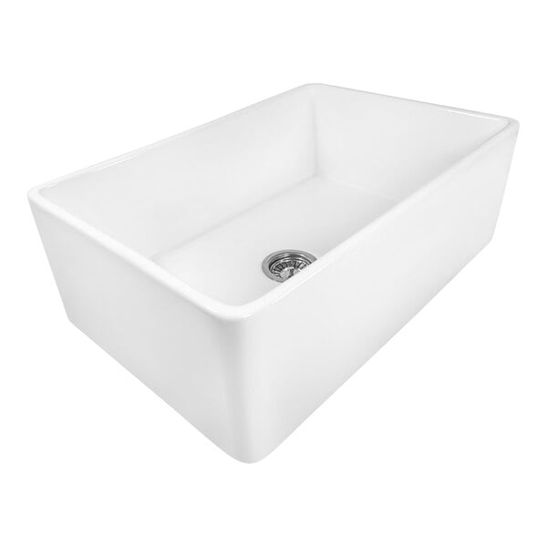 A Ruvati white fireclay farmhouse sink with a silver drain.