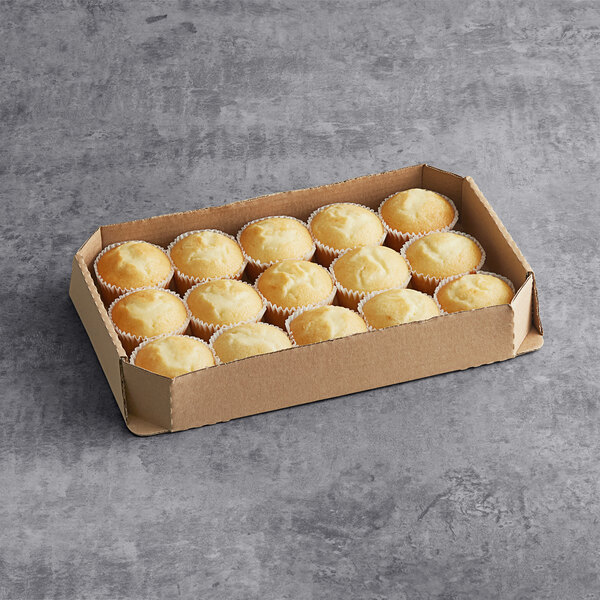 A white cardboard box of Brill Un-Iced White Cupcakes on a gray surface.