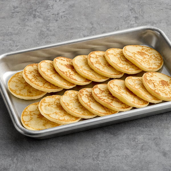 A tray of Le Chic Patissier Butter Mini Blini on a gray surface.