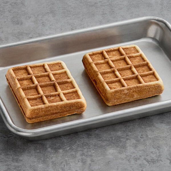 Two Le Chic Patissier mixed berry-filled waffles on a metal tray.