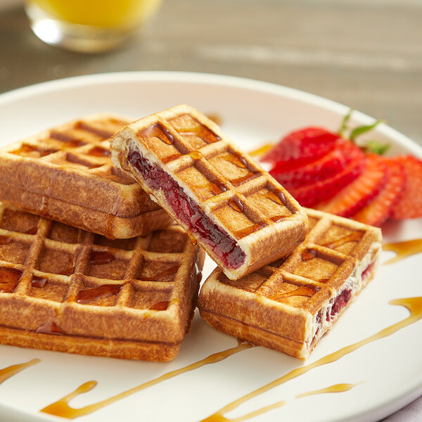 A plate with a Le Chic Patissier mixed berry-filled waffle with jam on top.
