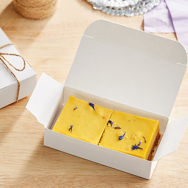 A white box of rectangular yellow Nats Rawline lime and mango cake squares.