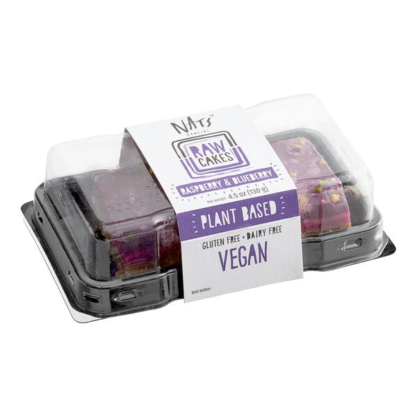 A plastic container of Nats Rawline vegan raspberry and blueberry cake squares with a label on it.