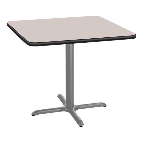 A National Public Seating square cafe table with a gray top and metal X base.
