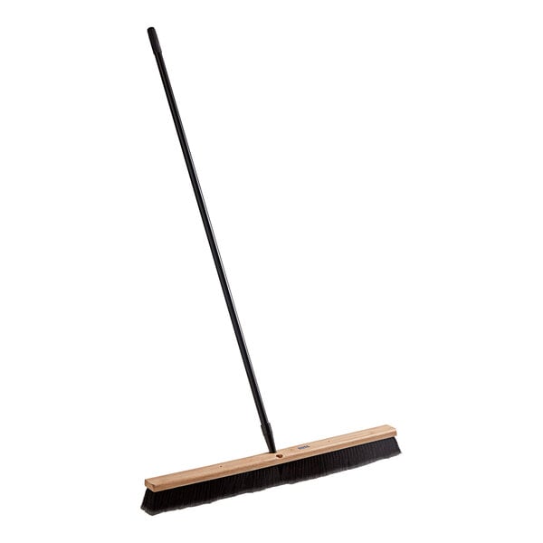 A Lavex push broom with a long wooden handle.