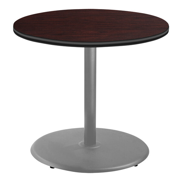 A National Public Seating round cafe table with mahogany surface and metal base.