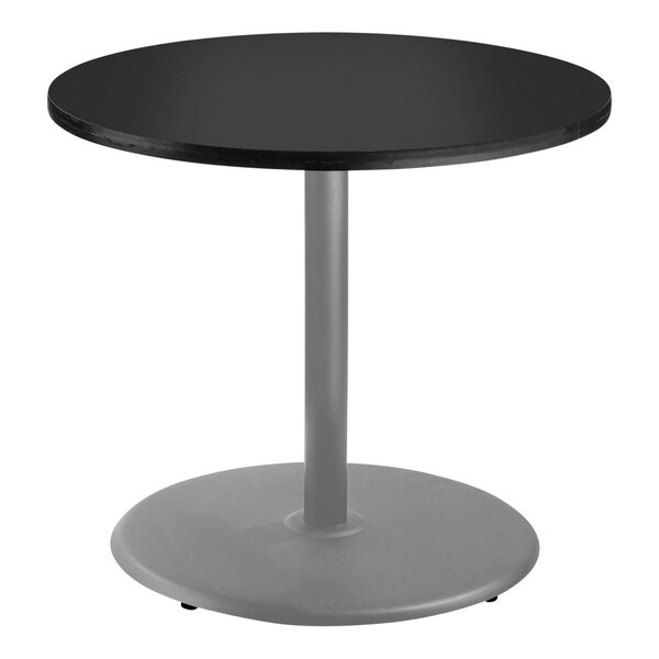 A National Public Seating round black table with a metal base.