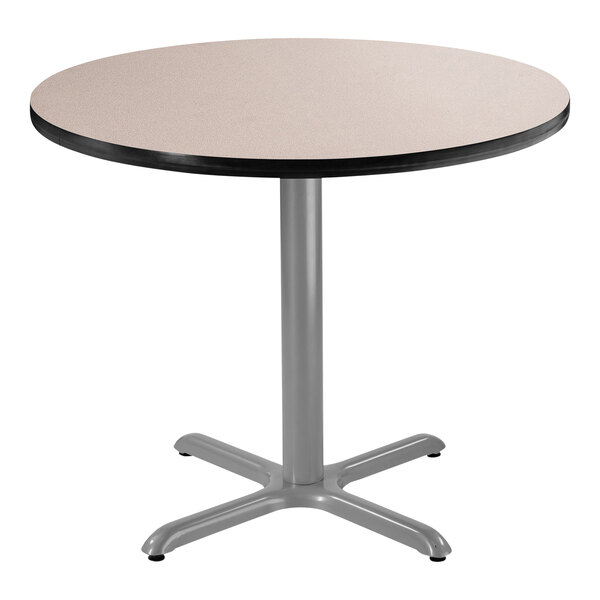 A round National Public Seating cafe table with a gray surface and metal base.