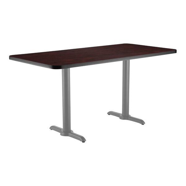 A National Public Seating rectangular cafe table with a mahogany top and metal T base.