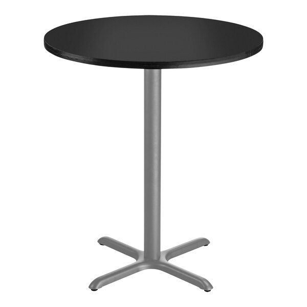 A round black National Public Seating bar height table with a gray X base.