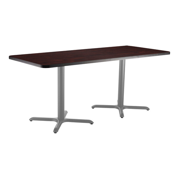 A National Public Seating rectangular cafe table with a mahogany top and metal X base.