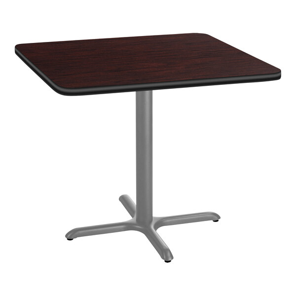 A National Public Seating square mahogany cafe table with a metal X base.