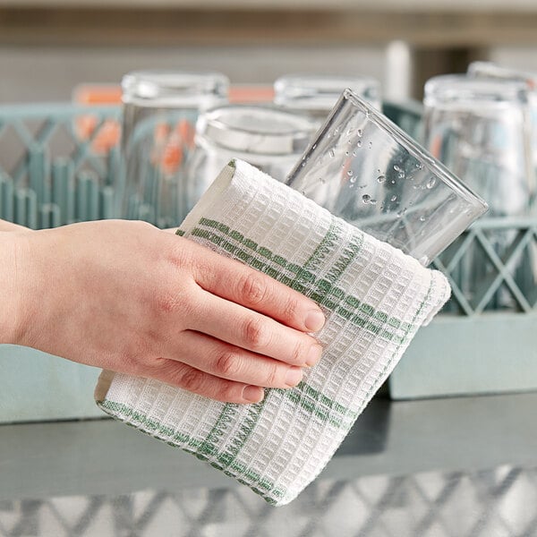 A hand holding a Choice striped waffle-weave dish towel over a glass.