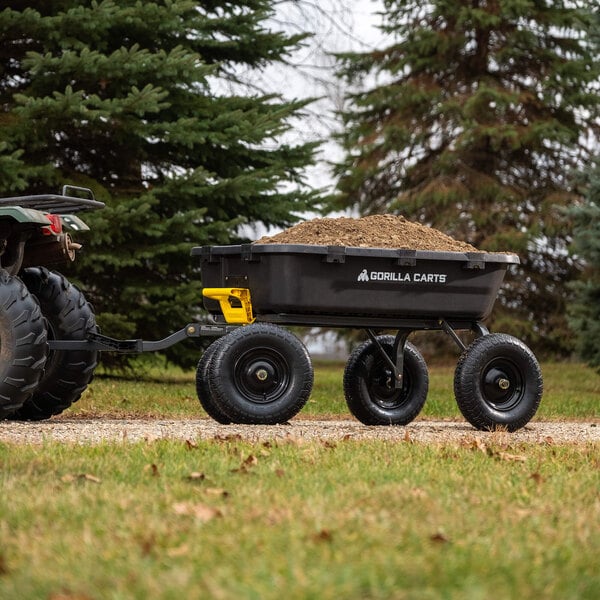 A black and yellow Gorilla yard dump cart filled with dirt.