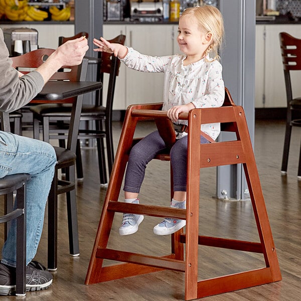 A man and a child in a Lancaster Table & Seating wooden high chair.