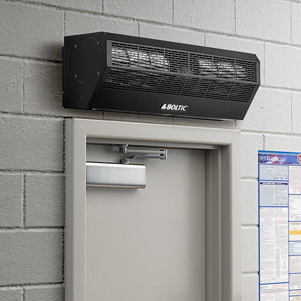 A black Boltic air curtain machine installed above a door.