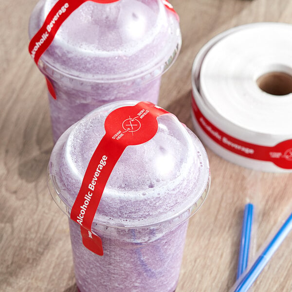 A table with two plastic cups of purple liquid with TamperSafe red paper drink labels on them.