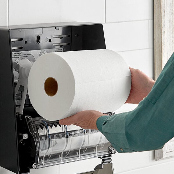 A hand holding a Morcon Morsoft paper towel roll.