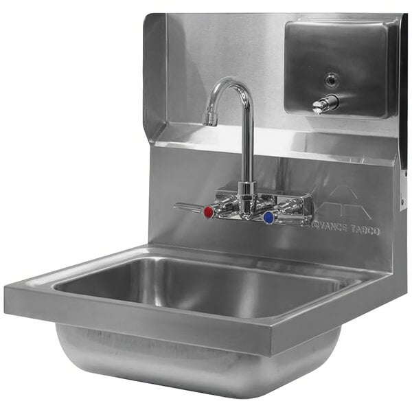 An Advance Tabco mounted stainless steel backsplash with a soap dispenser above a sink and faucet.