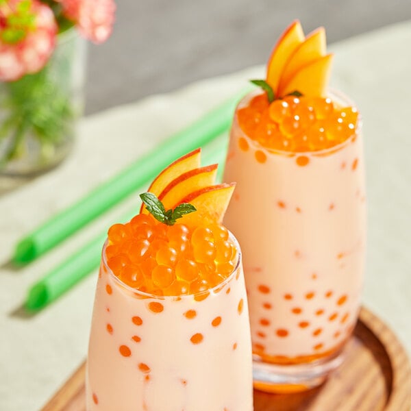 Two glasses of peach drinks with Bossen Pure25 Peach Bursting Boba on top.