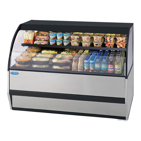 A Federal Industries black curved refrigerated display case on a deli counter with food and drinks inside.